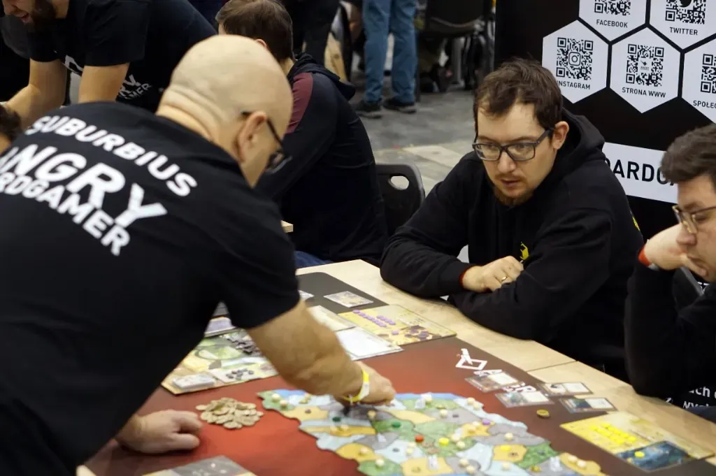 Prowadzący w koszulce Angry Boardgamer przy grze Arcs